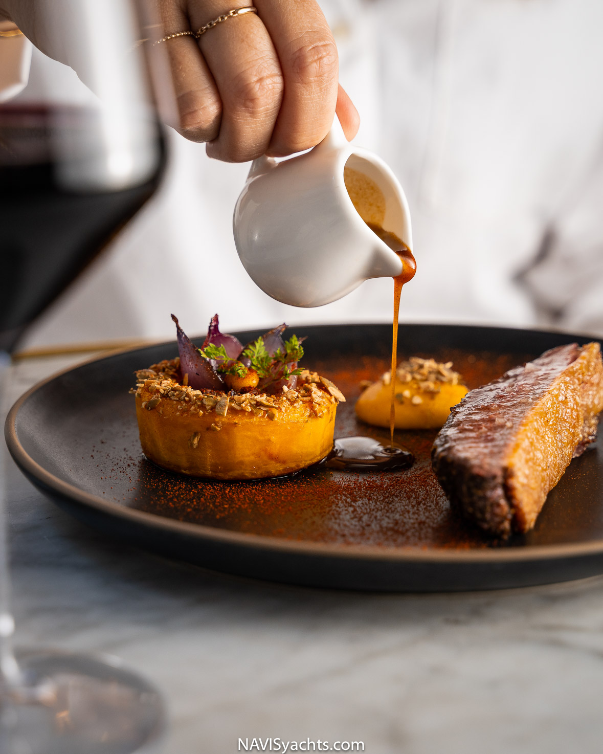 Roasted duck with roasted carrots, a visually stunning dish served at Benoit New York, resembling a renaissance painting.