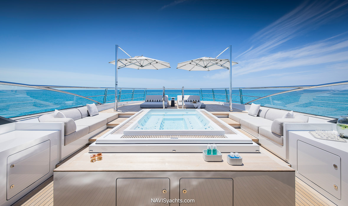 The tranquil and spacious interior of the motor yacht Entourage, revealing a soothing, light-filled lounge area with a gentle color palette, soft, organic shapes, and lush, comfortable furnishings designed by Burdifilek.