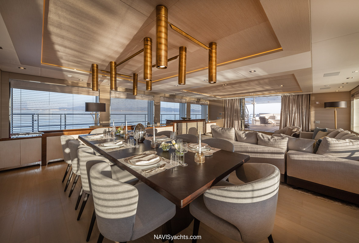 Spacious main deck salon on Benetti 50m M/Y AJ with panoramic sea views, elegantly furnished with Minotti sofas and Flexform poufs, enhancing the luxurious maritime ambiance.