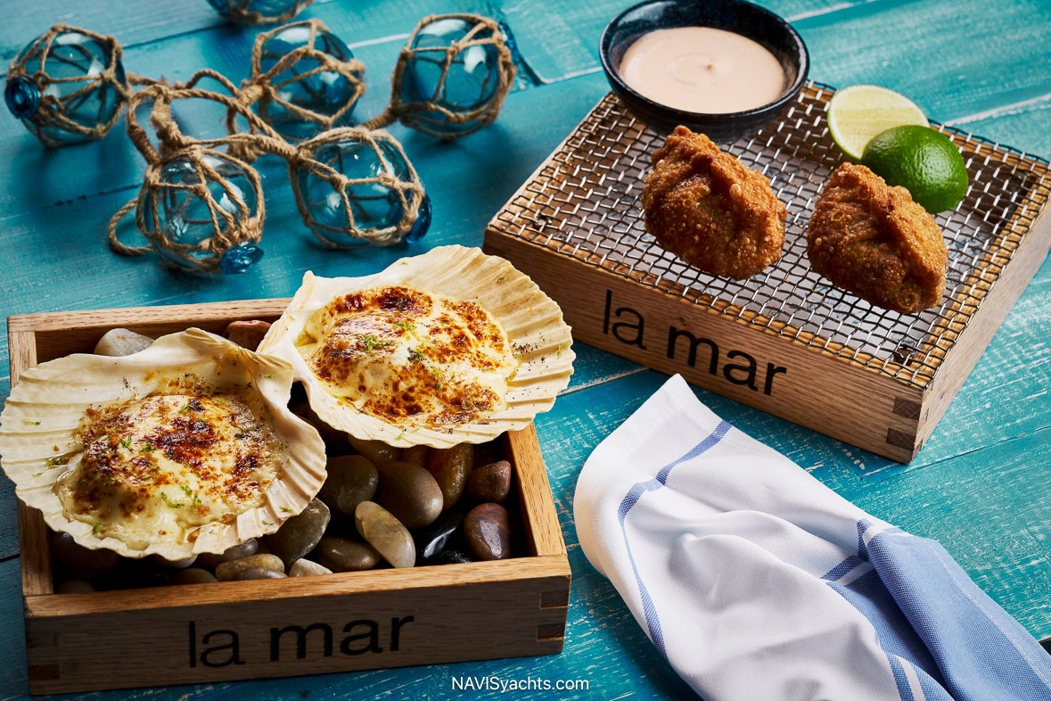 A vibrant and artfully plated cebiche tasting at La Mar, showcasing three distinct preparations on bold ceramic dishes that evoke Peruvian mountain and ocean colors.