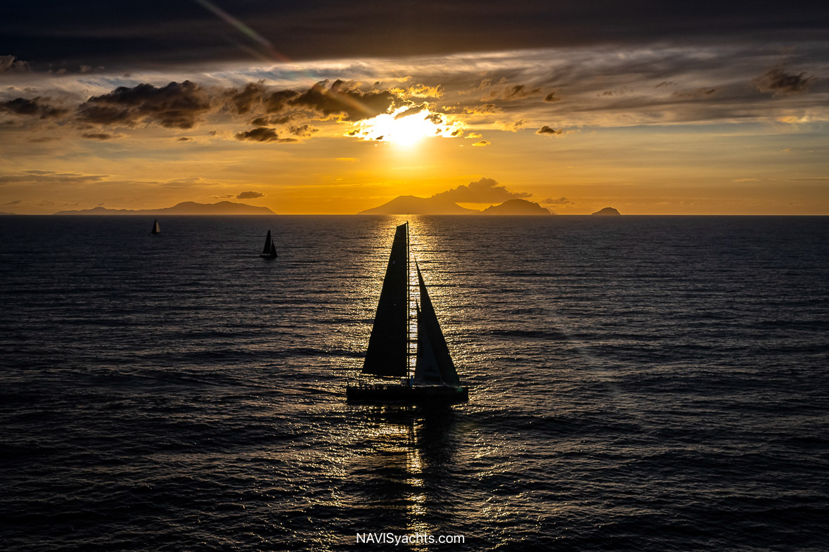 Yachts passing by the rugged shores of Pantelleria Island during the Rolex Middle Sea Race.