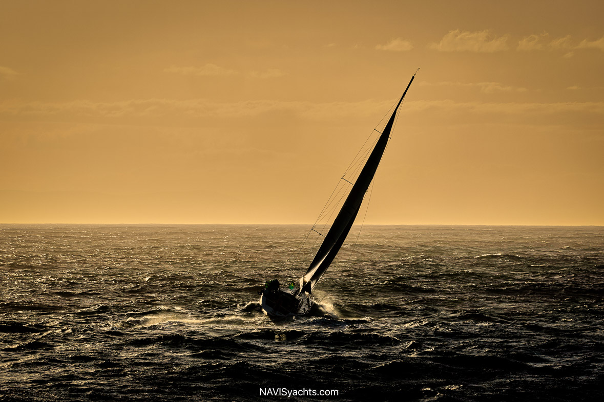 Yachts Battling Shifting Winds – Crews adjusting sails while navigating challenging conditions near Tasman Island.